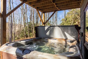 Un bain à remous doté d’une structure en bois et offrant une vue sur les arbres.
