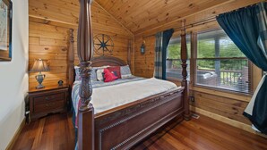Un dormitorio con paneles de madera, una cama con dosel, una mesita de noche, una lámpara y una ventana con cortinas.