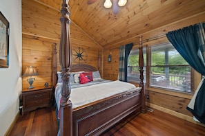 Ein Schlafzimmer mit Holzvertäfelung, einem Himmelbett, einem Nachttisch, einer Lampe und einem Fenster mit Vorhängen.