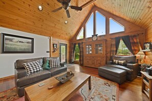A spacious living room with a high ceiling, wooden walls, a large window, and a cozy seating area. - Little Heaven - one Level! hot Tub, Multi Games, Pets Allowed, Sugar Mountain (Banner Elk)