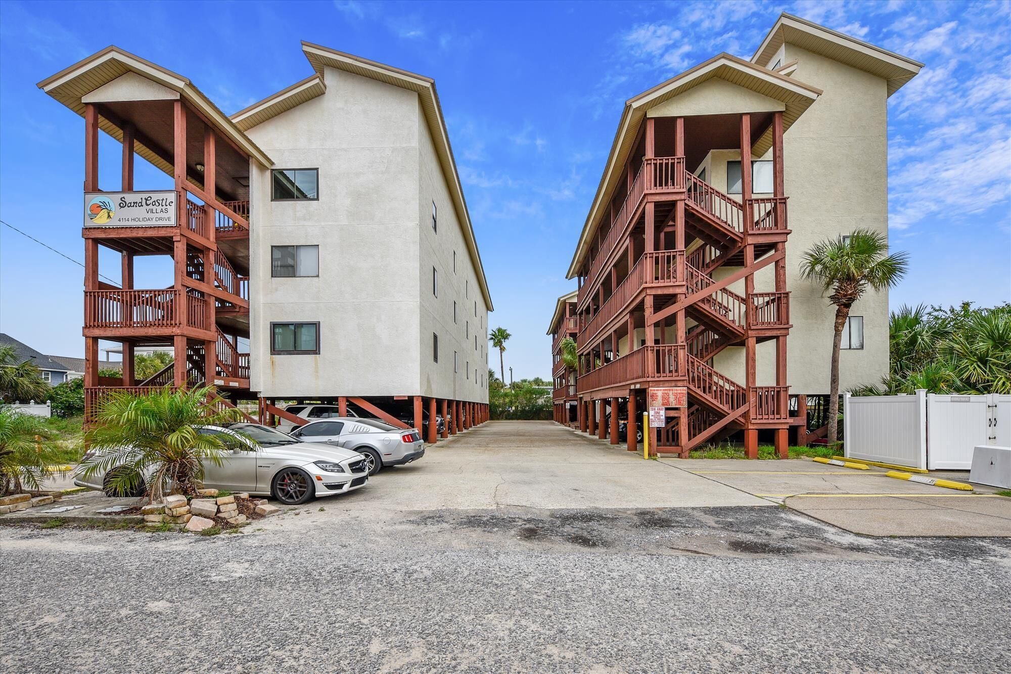 A hotel with a modern design, featuring a central courtyard with two cars parked.