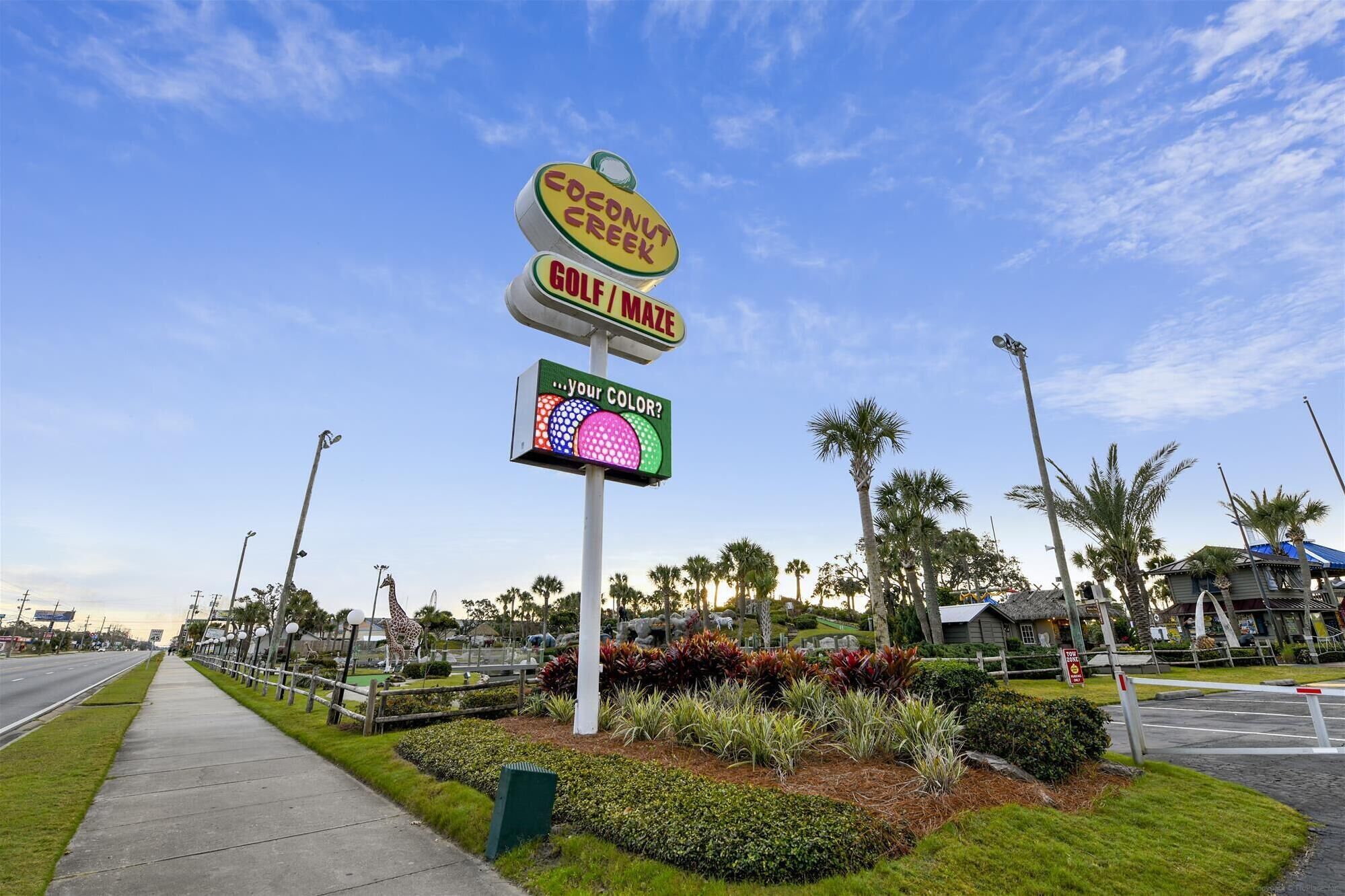 A roadside sign for a coconut creek golf maze with a 'Your color?' interactive display.