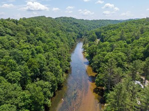 Eine Flusslandschaft aus der Vogelperspektive, umgeben von dichtem Wald.