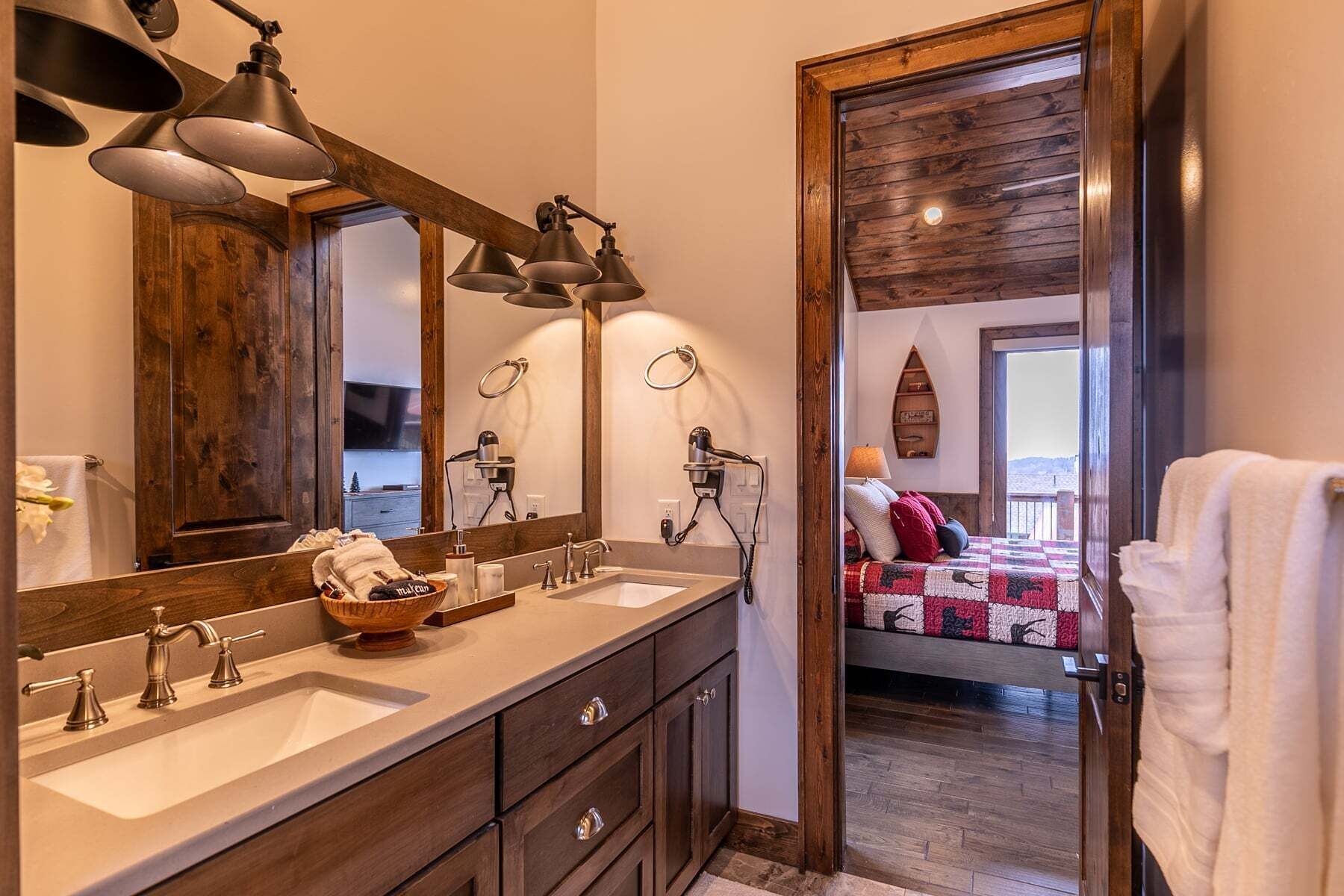 A bathroom with two sinks, a large mirror, and a hairdryer.