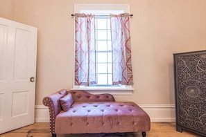 A room with a window, a door, a tufted sofa, and a decorative panel. - 406 Canyon Rd #1 (Ogden)