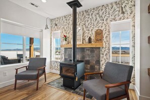 A room with a fireplace, two chairs, a window with a view, and a patterned wallpaper. - 405 Aspen Valley - Panguitch (Panguitch)