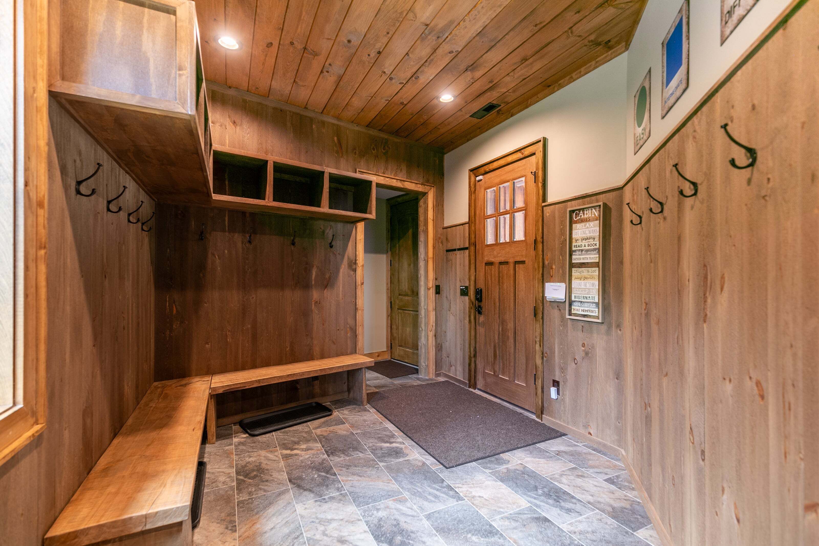 A wooden cabin interior with a bench, a door, and a signboard.