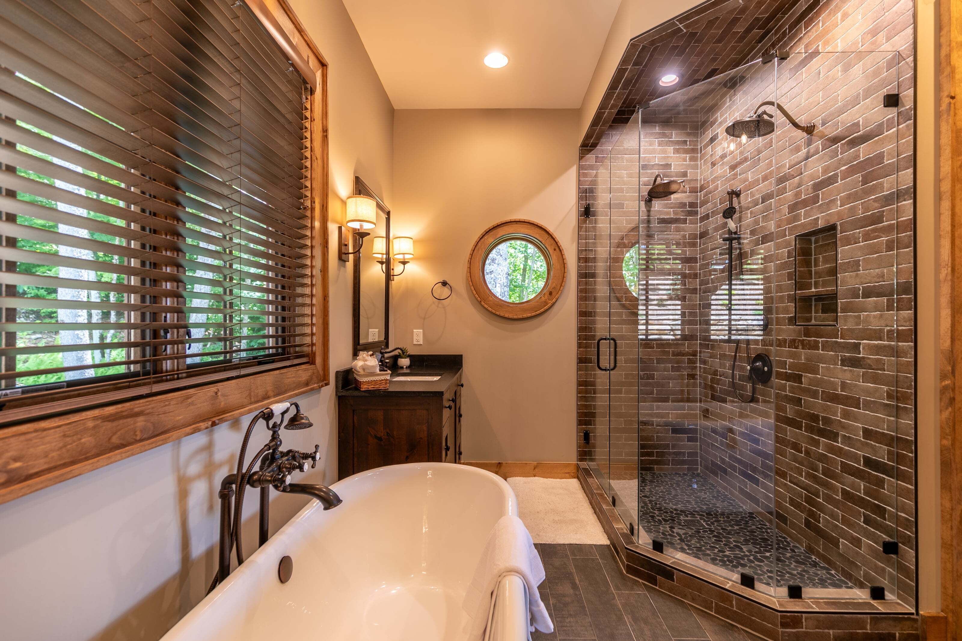 A bathroom with a freestanding bathtub, a glass-enclosed shower, and a wooden vanity.
