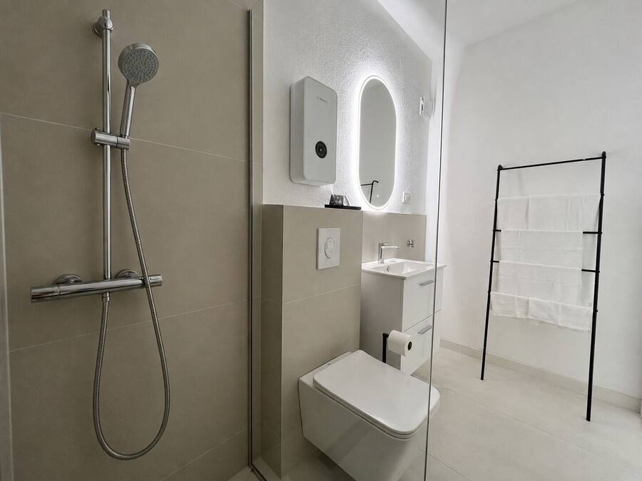 Ein modernes Badezimmer mit Dusche, Toilette und Waschbecken.