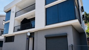 A multi-story hotel with a balcony, a closed garage door, and a sign indicating it is a hotel.