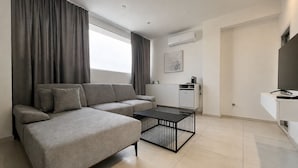 A modern living room with a sofa, a coffee table, and a TV.