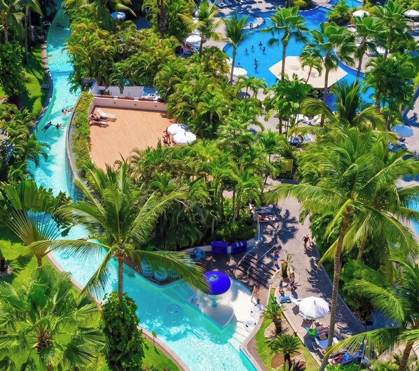 A resort with multiple swimming pools, palm trees, and lounge areas. - Luxury Beach Condo with Resort Access Vidanta (Nuevo Vallarta)