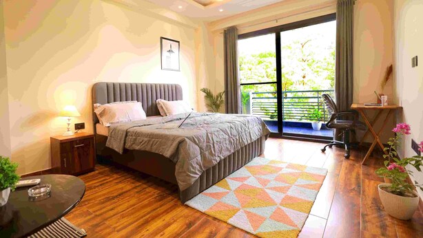 Ein modernes Schlafzimmer mit Bett, Nachttisch und Blick ins Freie.