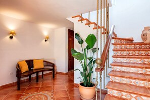 A staircase with patterned tiles, a wooden bench with cushions, a potted plant, and wall-mounted lights. - New! Villa Can Mila - Three Bedroom Villa, Sleeps 6 (Sant Joan de Labritja)