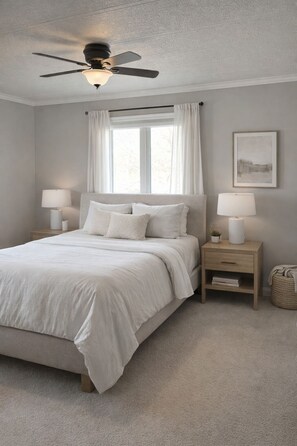 A bedroom with a bed, nightstands, a ceiling fan, a window with curtains, and a framed picture on the wall. - Flint Hills Country Escape - Dog and Horse friendly (Maple Hill)