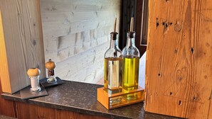 Una encimera de madera con dos botellas de vidrio, un salero y una pequeña caja negra.