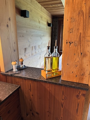 A wooden counter with two glass bottles, a salt shaker, and a small black box.