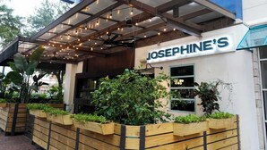 A restaurant named 'JOSEPHINE'S' with a covered outdoor seating area, wooden planters with greenery, and a modern architectural design. - Entire Midtown 4plex - Gated Parking - Rail to NRG (Houston)