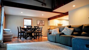 A living room with a sofa, a dining table with chairs, and a kitchen area with cabinets. - Peaceful 3BR Sunriver Home Close to Sharc & Village (Bend)
