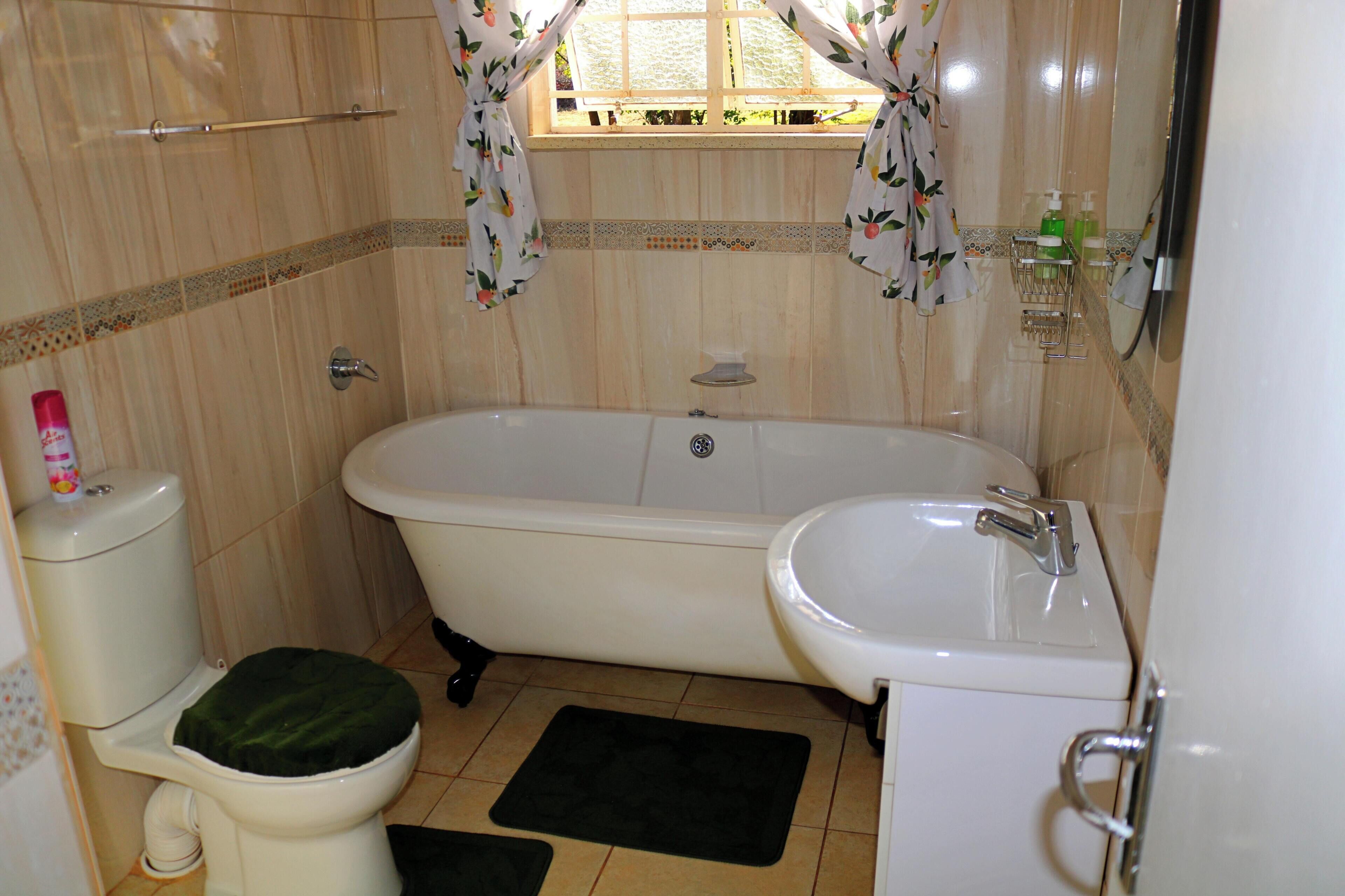 A bathroom with a bathtub, toilet, and sink.