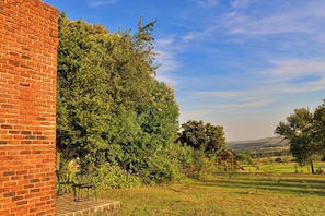 A brick building adjacent to a lush green area with a playground.