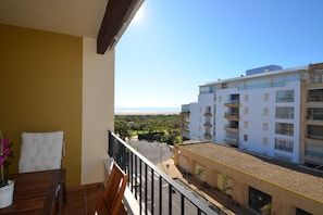 A balcony with a view of a beach and a multi-story building. - Playa Grande 23 - Two Bedroom Apartment, Sleeps 5 (Punta del moral)