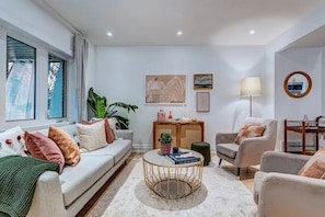 Un salon moderne comprenant un canapé, des fauteuils, une table basse et une table d’appoint agrémentée d’objets décoratifs.