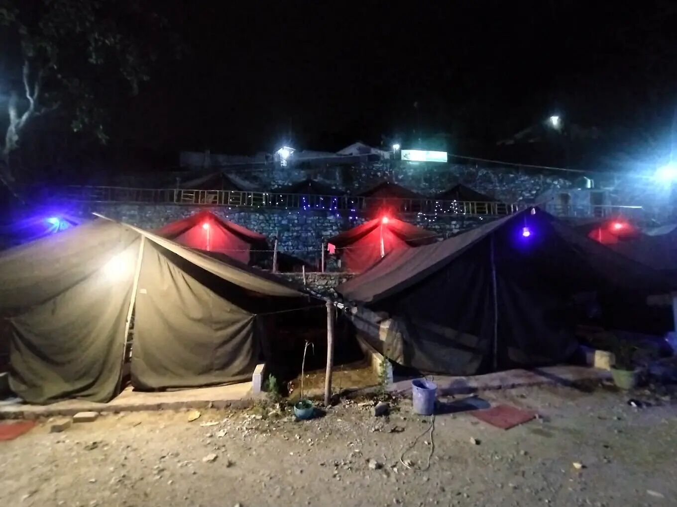 A row of tents with a fence in the background.