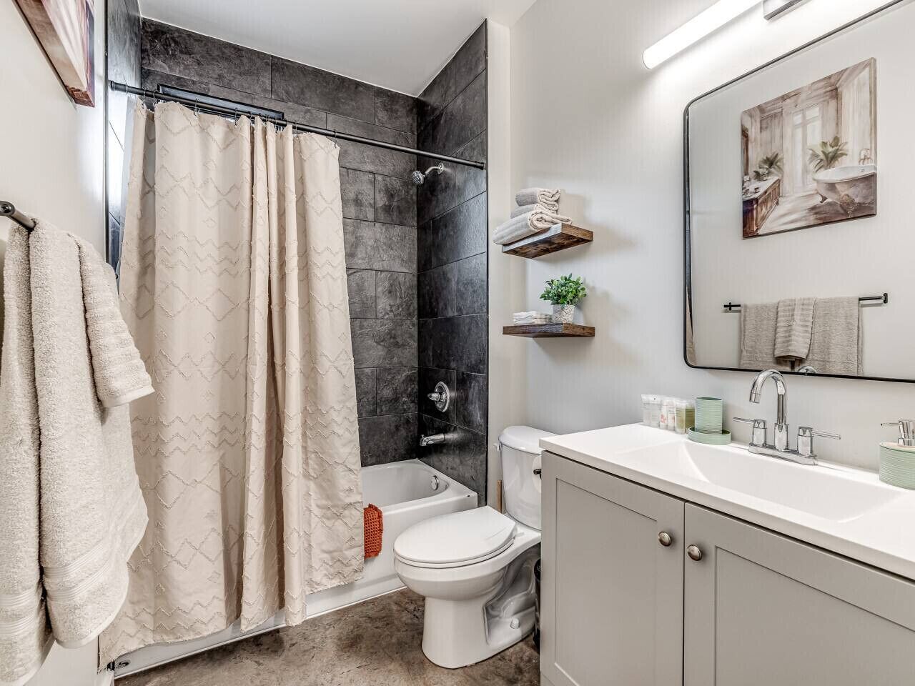 A modern bathroom with a shower, toilet, and sink.