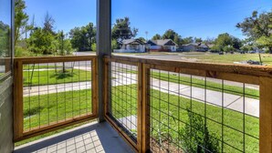 A balcony with a view of a residential street, houses, and a clear blue sky. - Midtown OKC 1Bed Hideaway (Oklahoma City)