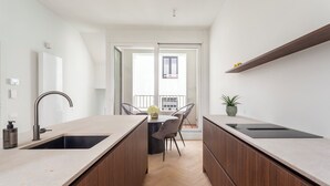 Eine moderne Küche mit zwei Spülen, einem Essbereich mit Tisch und Stühlen sowie einem Blick ins Freie.