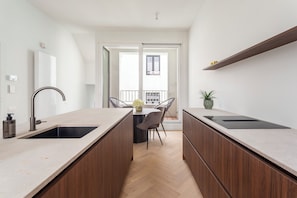 A modern kitchen with two sinks, a dining area with a table and chairs, and a view to the outside. - Stylish Second-Floor Apartment in Central Antwerp (Antwerpen)