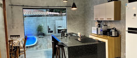A modern kitchen with a marble countertop, a built-in oven, and a refrigerator.