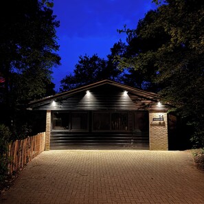 A building with a brick facade, large windows, and a wooden fence. - New: Luxury forest house in nature with private hot tub (Rheezerveen)