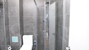 A modern bathroom with a glass-enclosed shower, a toilet, and a small towel rack. - Vicolo Moda kadıköy (İstanbul)