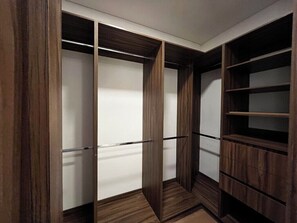 Ein begehbarer Kleiderschrank mit Holztüren und Regalen.
