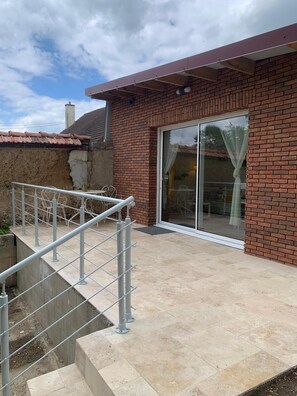 A brick house with a glass door and a concrete staircase.