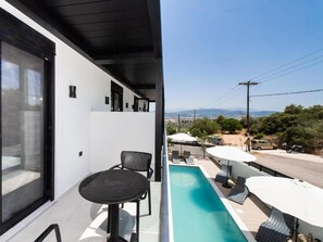 Un balcón con piscina, una mesa y sillas.