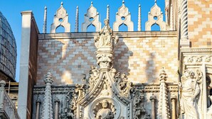 A detailed facade of a historic building with ornate carvings and a large arched entrance.
