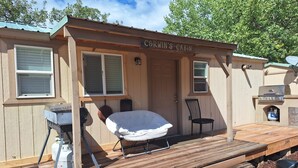A cabin named 'Corwin's Cabin' with a covered porch, a grill, and a chair. - Beautiful 1-bedroom cabin with AC in charming Glendale (Glendale)