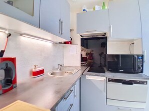 Eine moderne Küche mit integriertem Mikrowellenherd, Geschirrspüler und Kaffeemaschine.