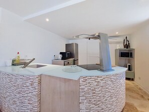 Eine moderne Küche mit einer zentralen Kochinsel, integrierten Geräten und minimalistischem Design.