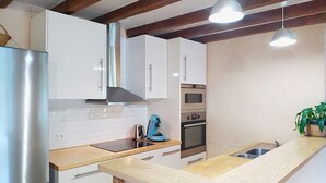 A modern kitchen with stainless steel appliances, wooden countertops, and pendant lighting. - L'ancienne Ferme by Interhome (Lestre)