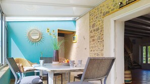 A dining area with a round table, chairs, and a vase of flowers. - L'ancienne Ferme by Interhome (Lestre)