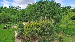 A garden with a variety of plants and a small structure. - L'ancienne Ferme by Interhome (Lestre)