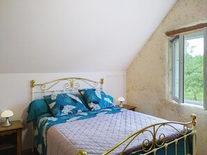 A bedroom with a bed, two bedside tables, a window, and a view of greenery outside. - L'ancienne Ferme by Interhome (Lestre)