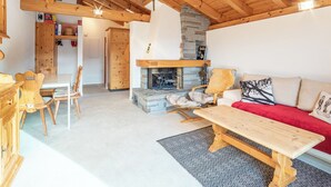 Un intérieur en bois avec une cheminée, un canapé et un coin repas.