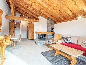 A wooden interior with a fireplace, a sofa, and a dining area. - Apartment Ansiel by Interhome (Falera)