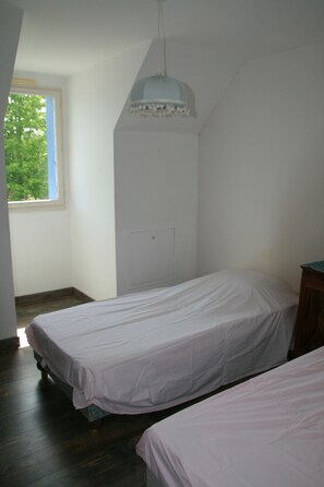 A room with two beds, a window, and a white ceiling light. - Quiet vacation home for families (Piriac-sur-Mer)