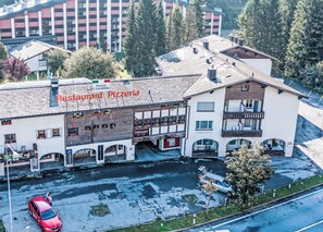 Ein mehrstöckiges Gebäude, im Erdgeschoss befindet sich ein Restaurant namens 'Restaurant Pizzeria'.